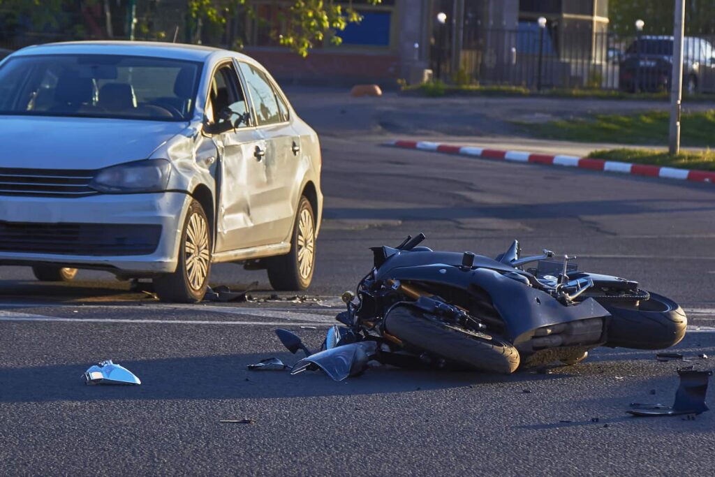 Left-Turn Motorcycle Accident on Long Island – Proving Fault Left-turn motorcycle accident scene on Long Island with damaged car and fallen bike at intersection