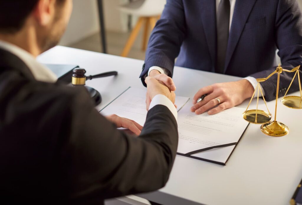 motorcycle accident lawyer consultation handshake helmet defense injury claim New York legal strategy meeting